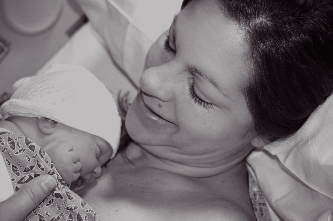 black and white photo of a new mom having skin to skin time with her new baby girl after her c-section birth - Charleston SC birth photographer