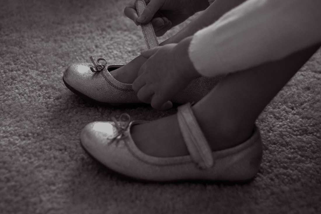 black and white photo of little girl putting on her shoes Charleston, SC lifestyle photography