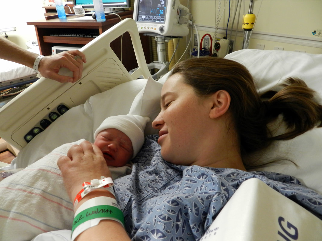 Mother holding newborn baby in recovery after c-section birth