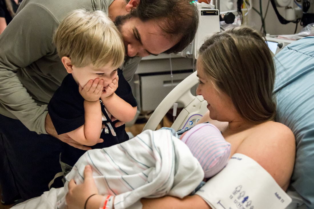 photo of new big brother meeting baby sister for the first time - Charleston area birth photographer south carolina