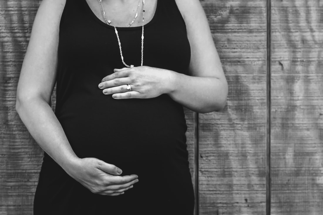 Black and white photo of a mother's hands on her pregnant belly during a maternity session | Charleston, SC maternity photographer