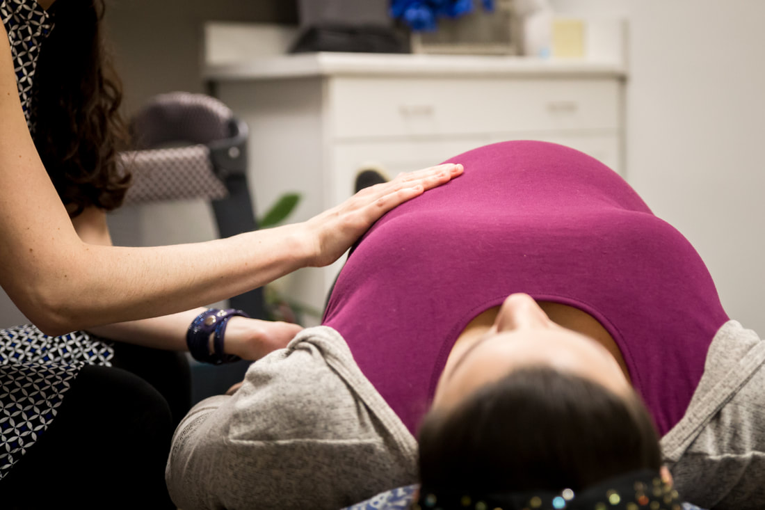 Photo of a female chiropractor adjusting a pregnant woman