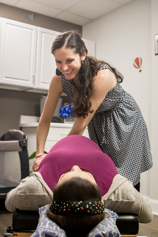 Photo of a female chiropractor adjusting a pregnant woman