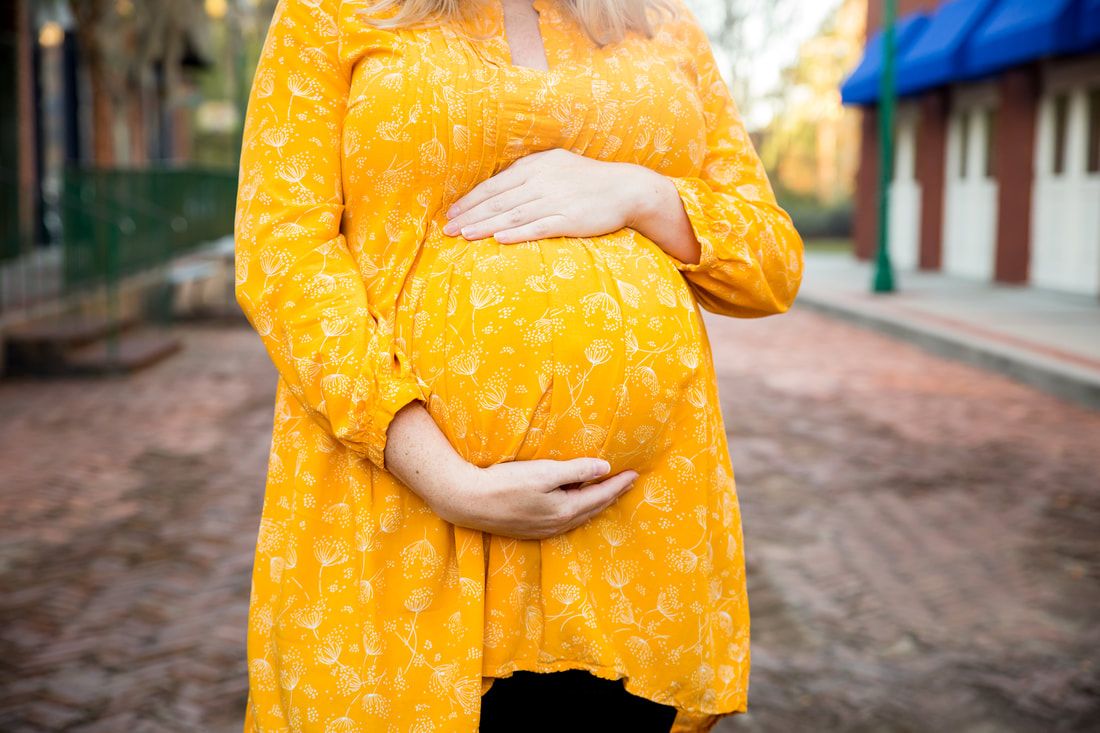 close up image of a mother's hands on her pregnant belly - maternity portraits - charleston, sc