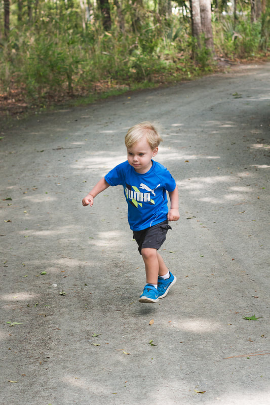 Toddler boy in blue t-shirt running